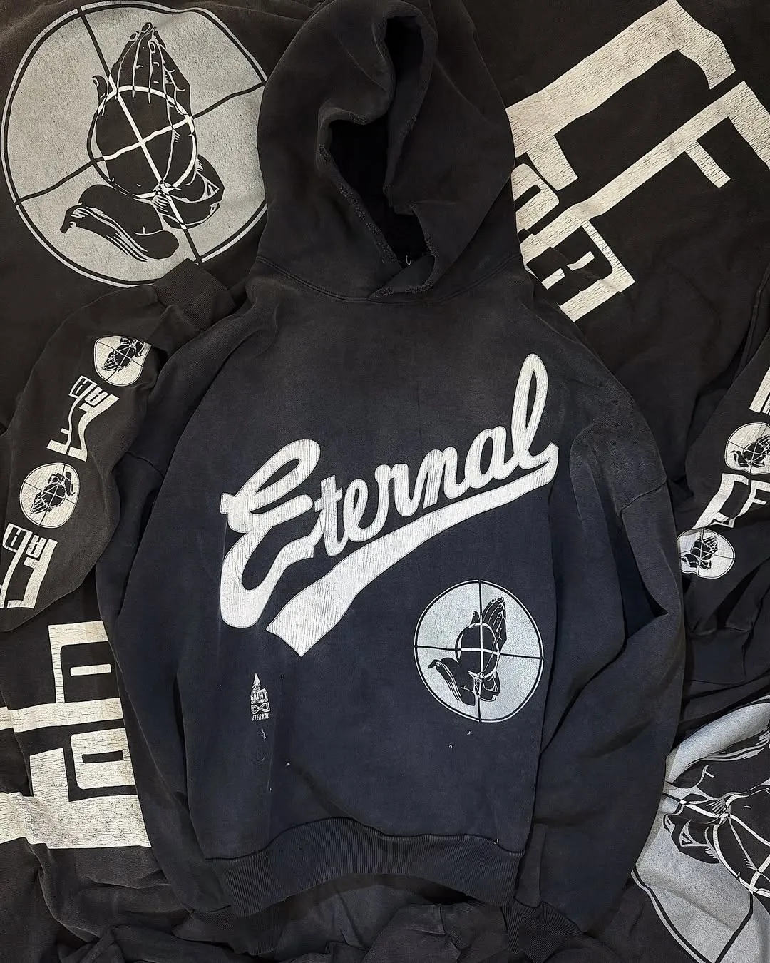 SAINT Mxxxxxx × FEAR OF GOD FG_HOODIE/SNT OF GOD/BLK FOG joint model ETERNAL praying crosshair distressed hoodie. Washed black S-XL. This season's popular super popular joint model. The original version is the same. Thin spring and summer fabrics. The upper body is comfortable. The BOXY version of the short fat wide shoulder line. Fashion darling wears it with a high-end feel. Heavy washing and water fading technology. The horse is repositioned. Excessive wear and damage graffiti treatment. Correct version FOG joint main mark/wash mark/little angel mark